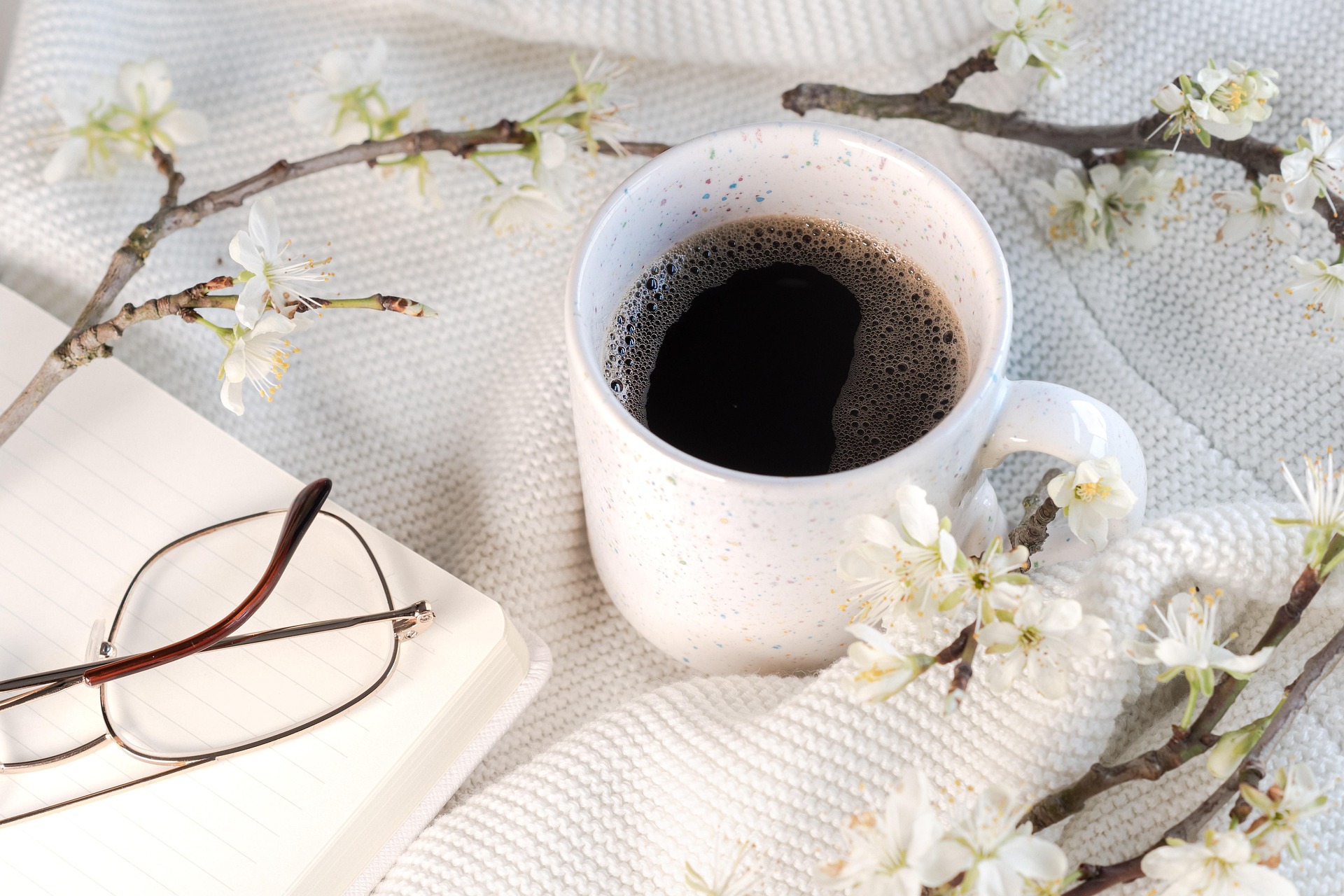 Coffee, flowers, and notebook on a cafe table