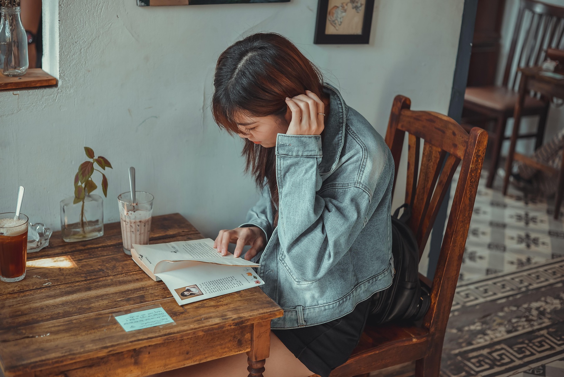 Guest reading a book in a sunlit cafe lounge