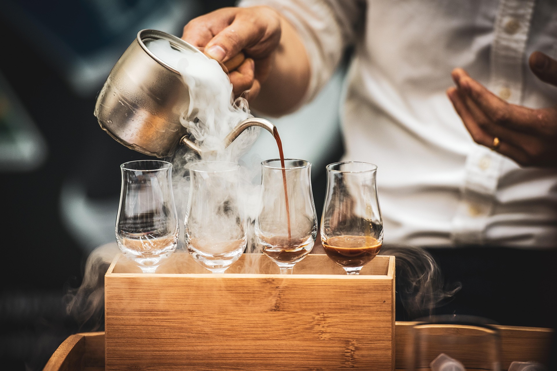 Barista pouring espresso into a latte